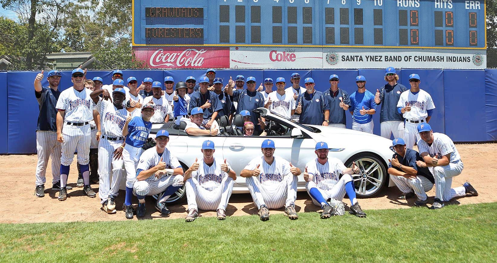 Team posing with white car