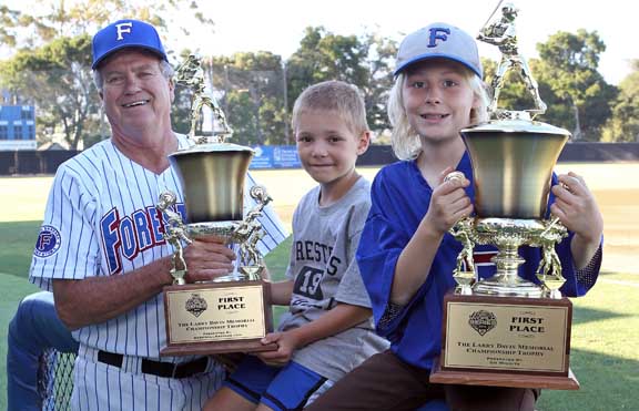 Coach and kids holding trophies