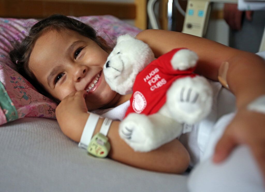 Child in hospital with Hugs for Cubs stuffed animal